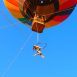 Foto de artista pendurada em um balão dançando no ar