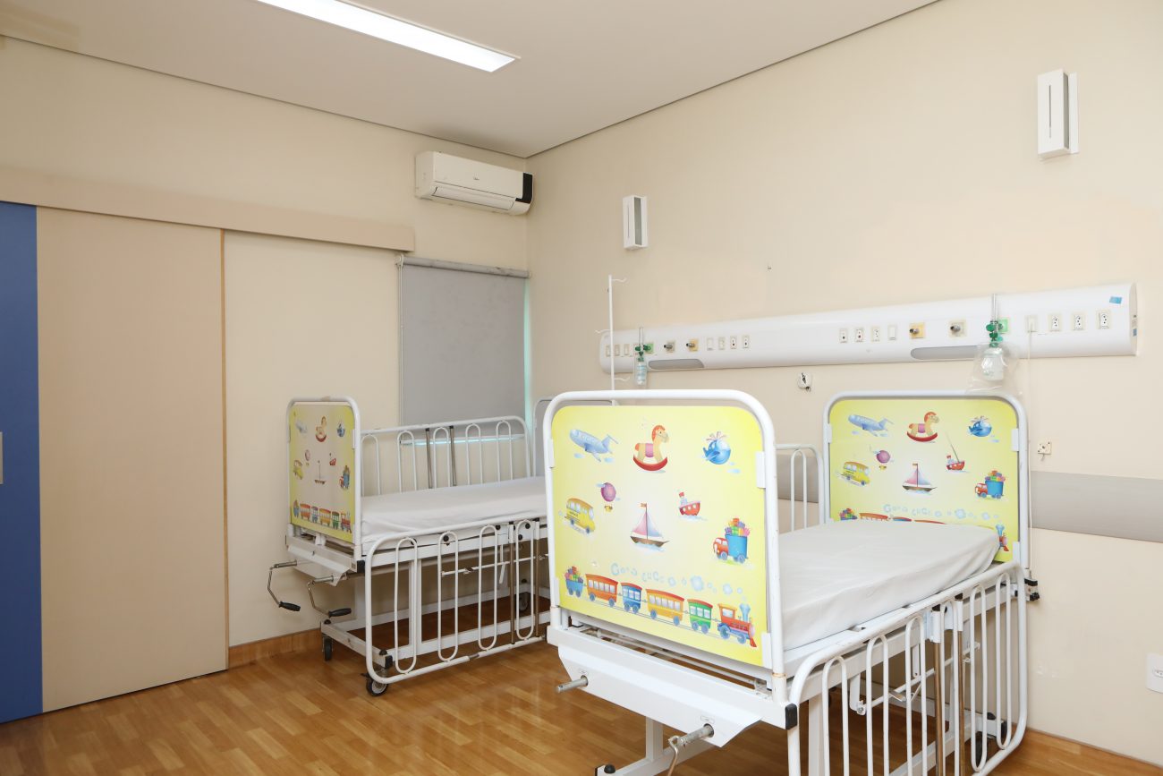 Fotografia colorida apresenta um quarto de hospital infantil, contendo dois berços