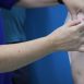 Imagem mostra os braços de um profissional de saúde aplicando a vacina contra Covid em uma cidadã