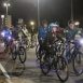 Imagem mostra alguns ciclistas no período da noite realizando um passeio ciclístico.