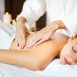 Imagem mostra mulher jovem recebendo massagem relaxante. O curso de massagem relaxante será oferecido conforme informado.