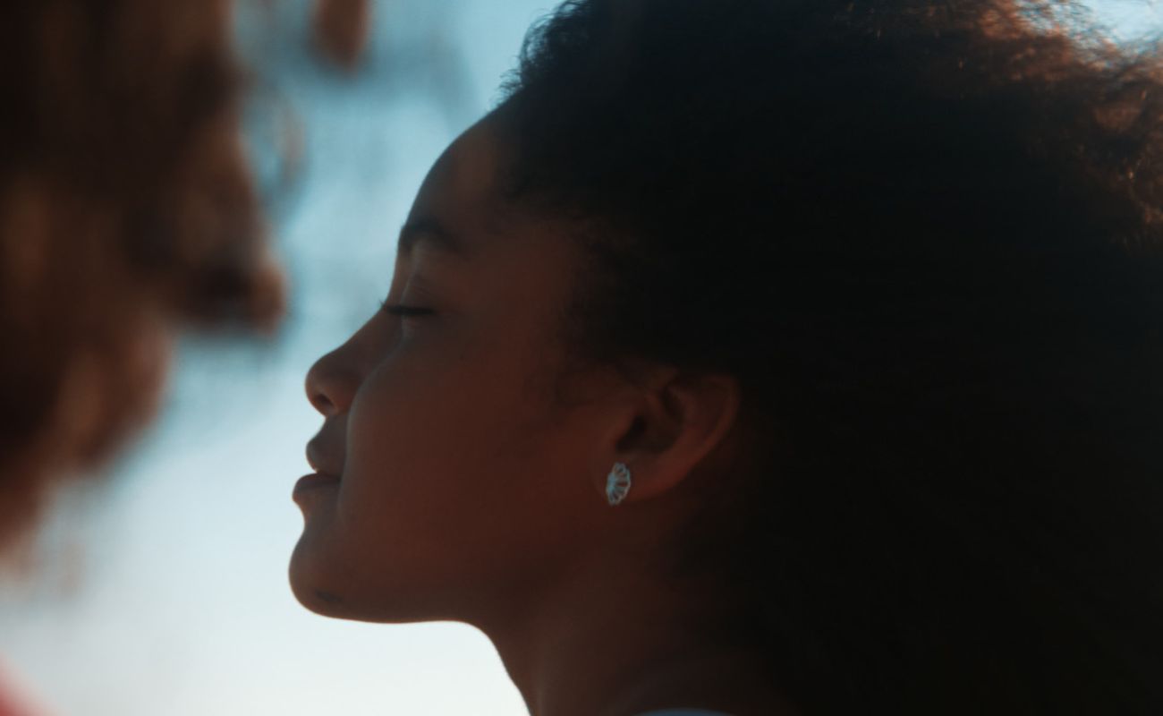 Imagem mostra o rosto de uma mulher negra de perfil. Esta faz parte da divulgação da 6º Mostra Livre de Cinema.