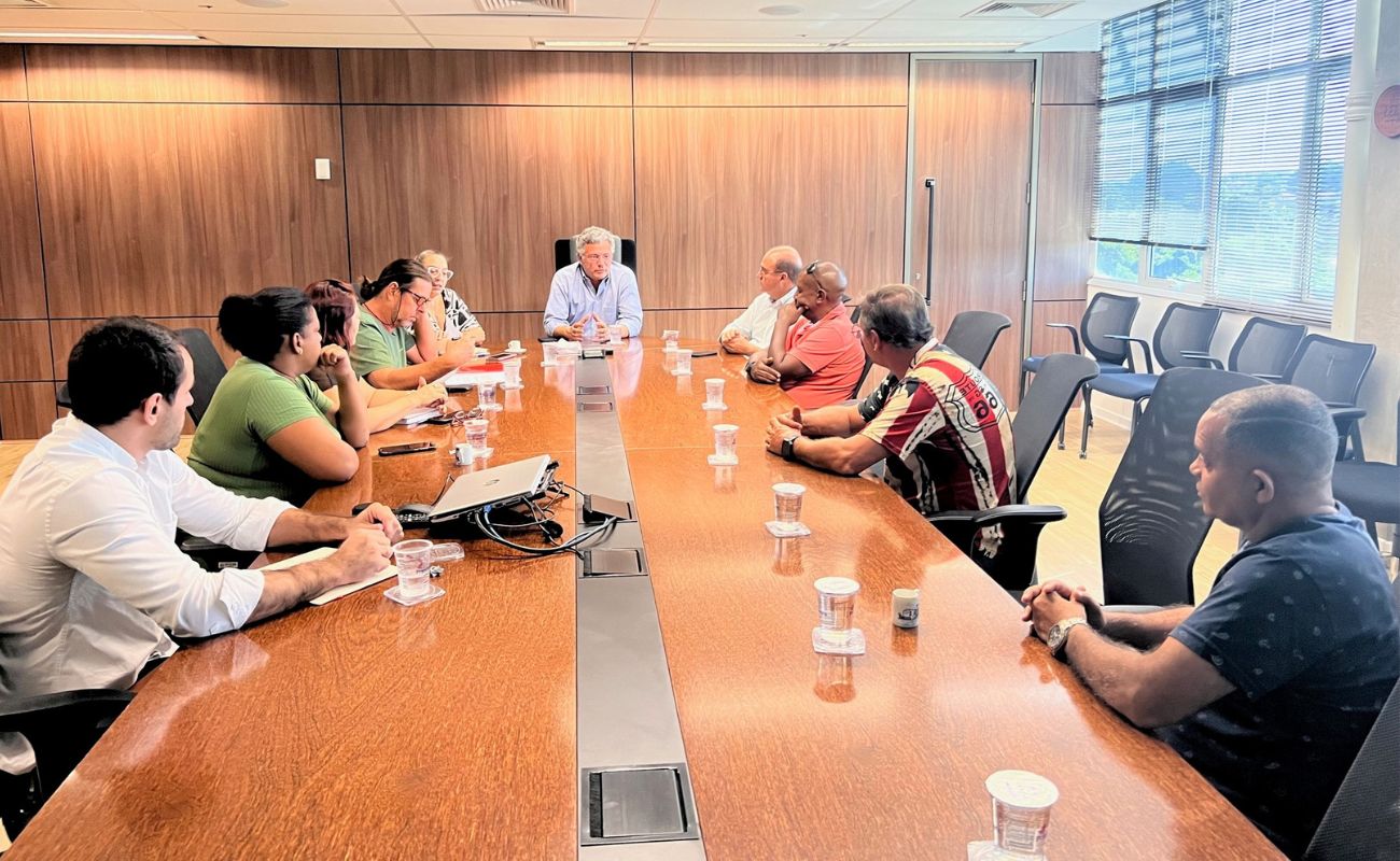 Imagem o prefeito Guilherme Gazzola sentado em uma mesa grande na sala de reuniões do seu gabinete, junto a nove servidores municipais, em debate do projeto de lei pleiteando o aumento salarial para os servidores municipais.