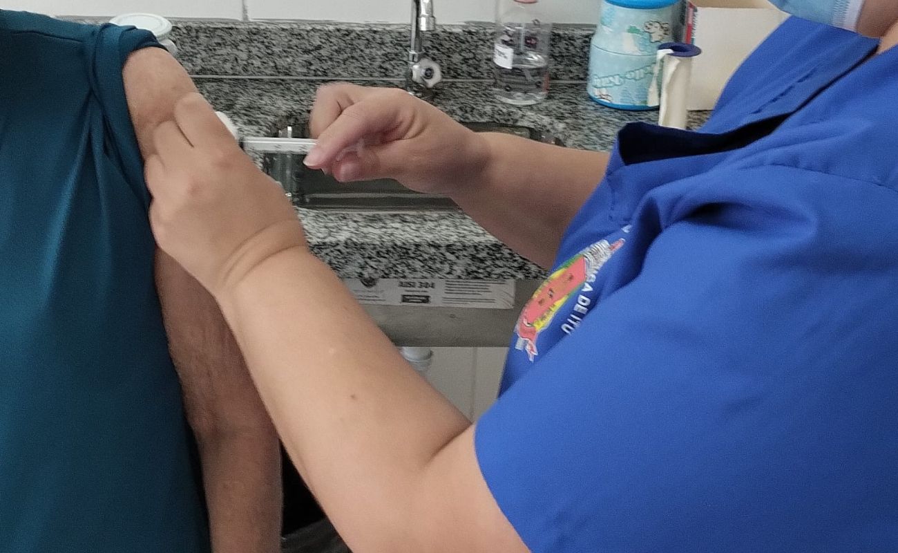 Imagem mostra uma pessoa recebendo a vacina contra Covid-19 em seu braço esquerdo em uma das campanhas de vacinação realizadas na cidade.