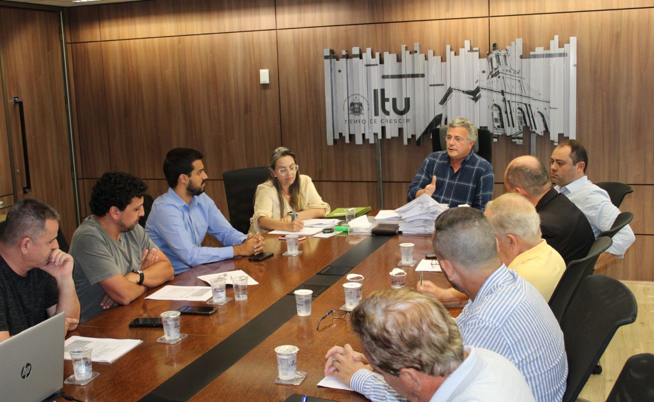 Imagem mostra o prefeito Guilherme Gazzola junto a autoridades municipais em um momento de reunião sobre o Projeto de Lei referente a redução da taxa de lixo.