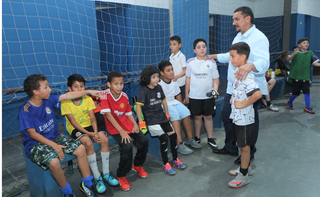 Imagem mostra o Secretário de Esportes Gilmar Pereira junto as crianças participantes da Copa Futsal Menores