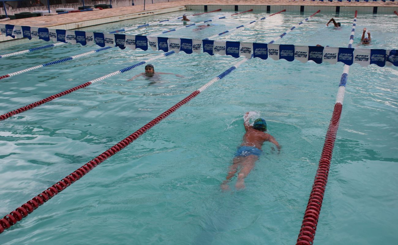 Imagem mostra duas crianças nadando na piscina do Estádio Novelli Junior, o local está com inscrições abertas para aulas de natação.