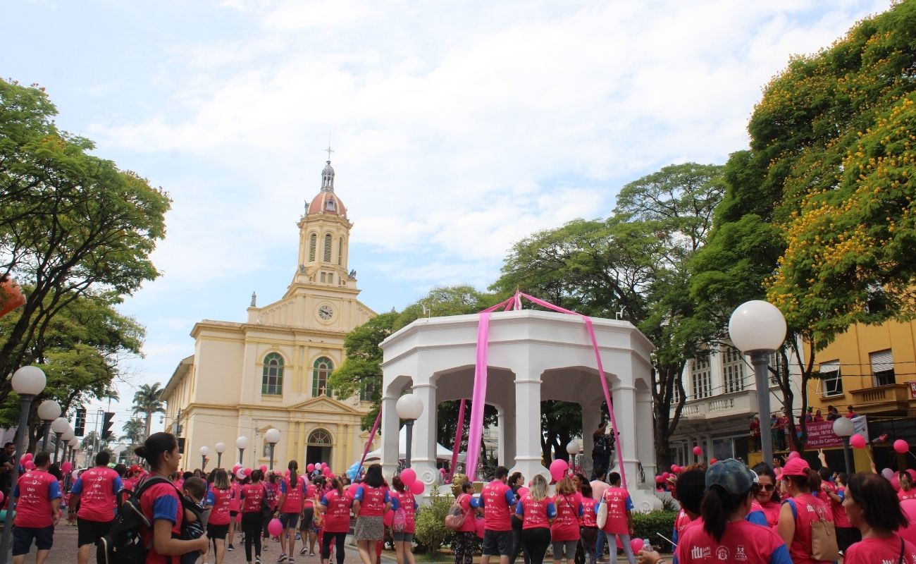 Imagem mostra pessoas com camisetas na cor rosa em caminhada Outubro Rosa