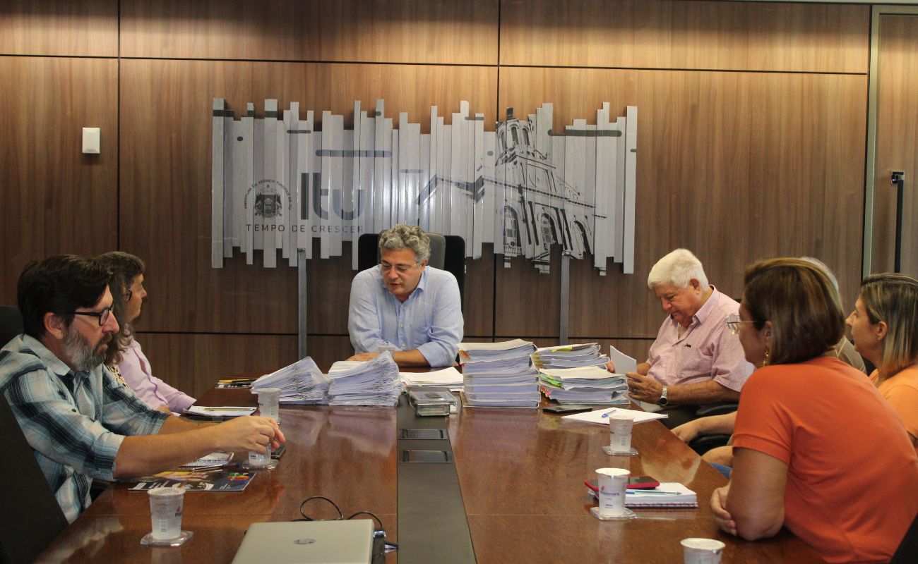 Imagem mostra o prefeito Guilherme Gazzola e equipe com técnicos da Itesp em reunião para regularização de lotes na Vila Martins e Jd. das Rosas.