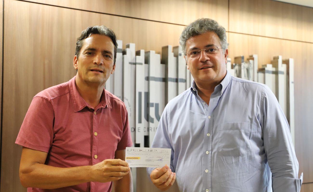 Imagem mostra o prefeito Guilherme Gazzola junto ao presidente da Câmara Normino em momento de devolução do cheque com valor de R$ 3 milhões, da Câmara.