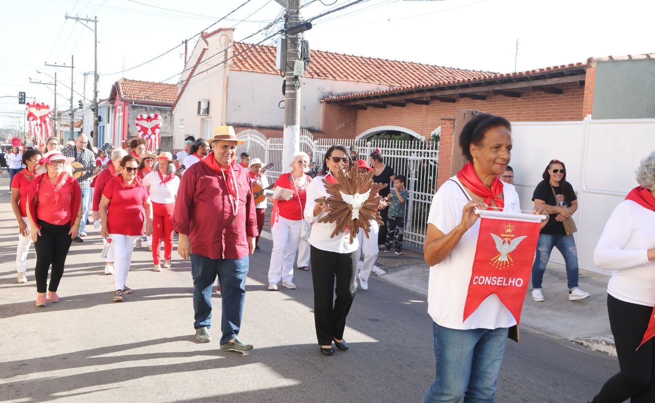 Imagem mostra pessoas transitando pela via levando a imagem do Divino Espírito Santo, em edição anterior do tradicional Desfile do Divino