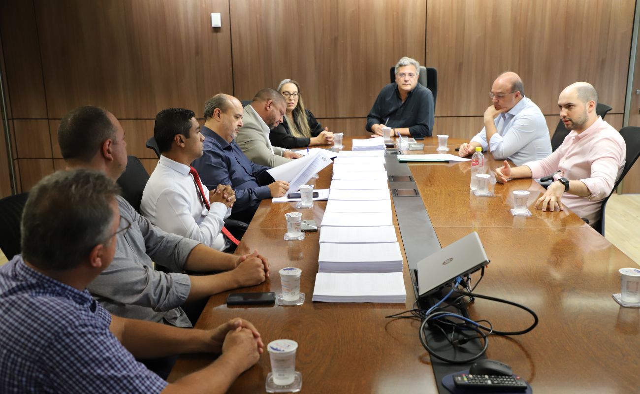 Imagem mostra o prefeito Guilherme Gazzola e sua equipe sentados na sala de reunião do gabinete junto a comissão de transição oficialmente nomeada