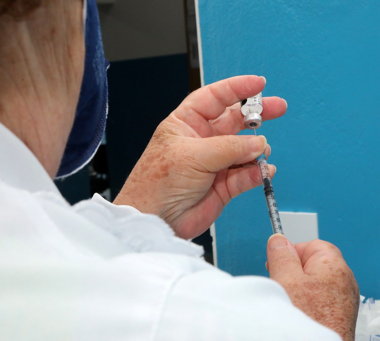 Foto de profissional de enfermagem preparando dose da vacina
