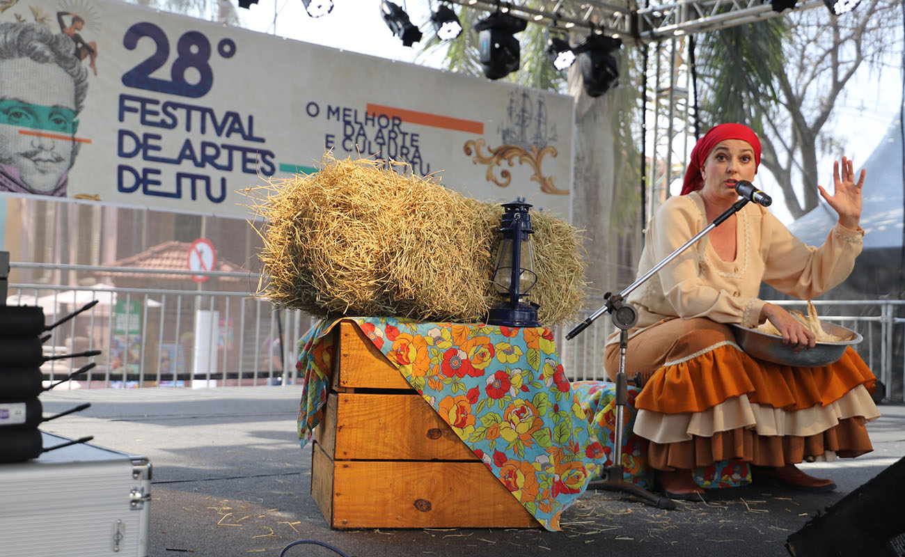 Imagem de artista sentada no palco pronta para fazer sua apresentação no festival