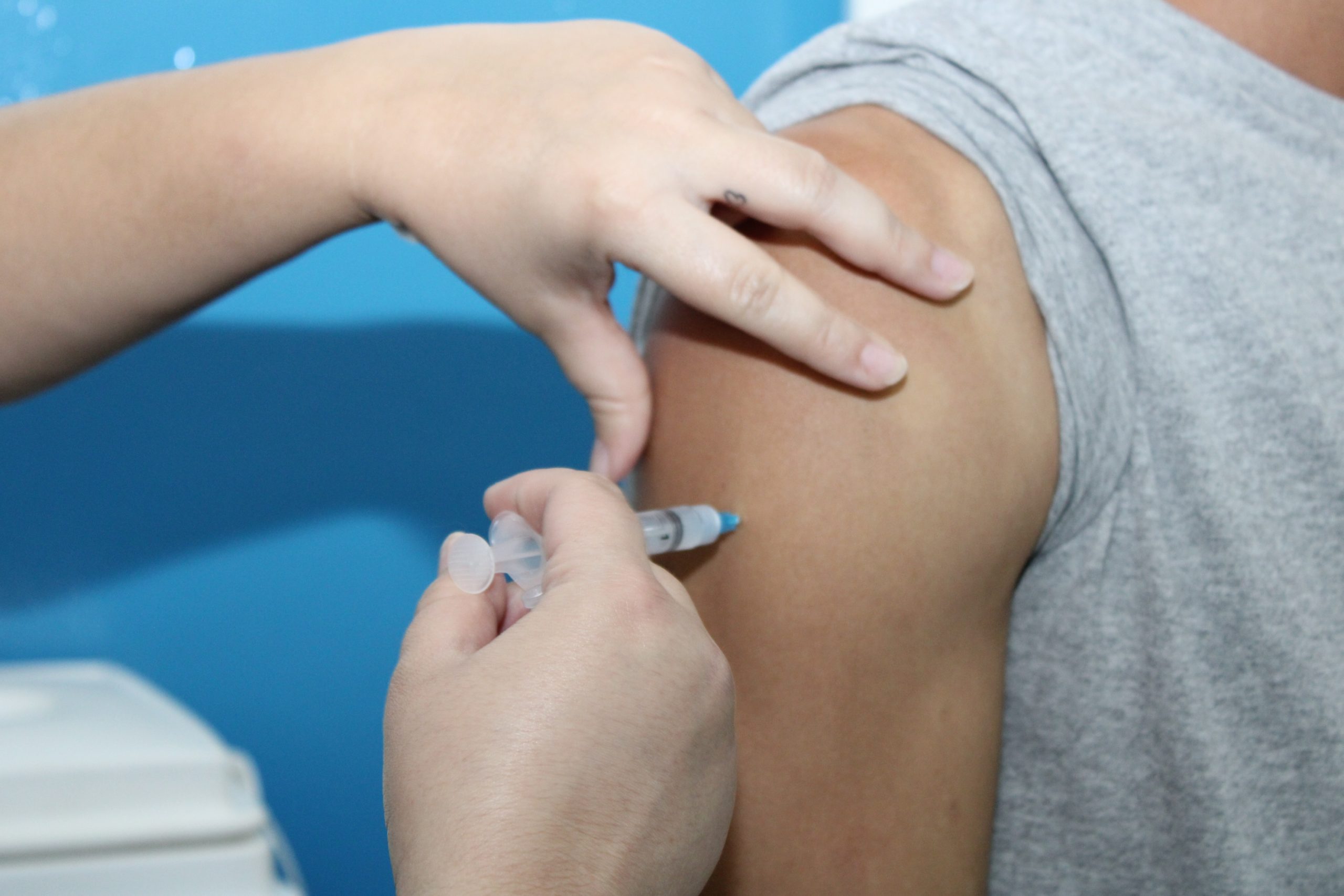Foto de pessoa recebendo a aplicação da vacina no braço esquerdo