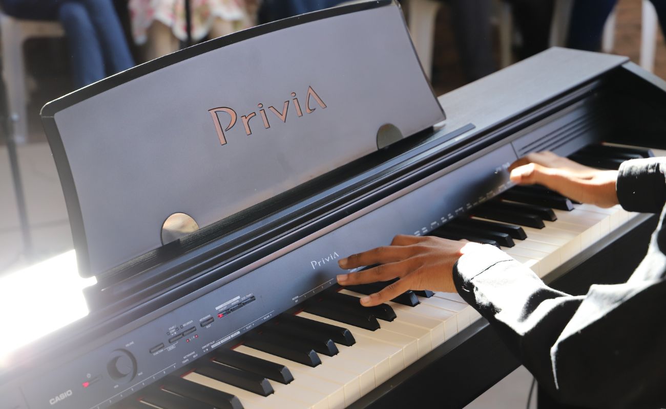 Foto mostra as mãos de uma pessoa tocando um teclado