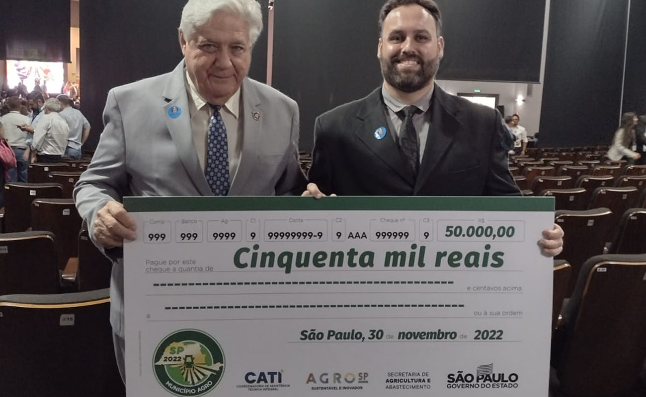 Foto do secretário de emprego Olavo Volpato recebendo o cheque da premiação do Programa Município Agro 2022