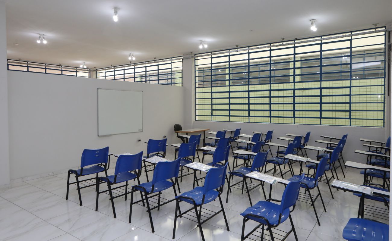 imagem mostra uma sala com cadeiras e um quadro branco.