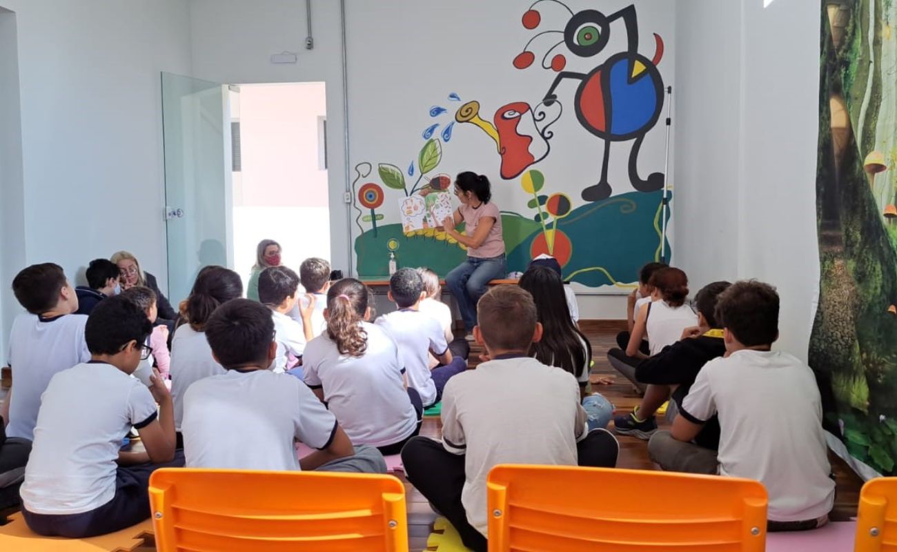 Imagem mostra crianças de costas ouvindo uma história contada por uma mulher. O local é o Centro Ituano de Letras e Artes, que completa 1 ano de exitência