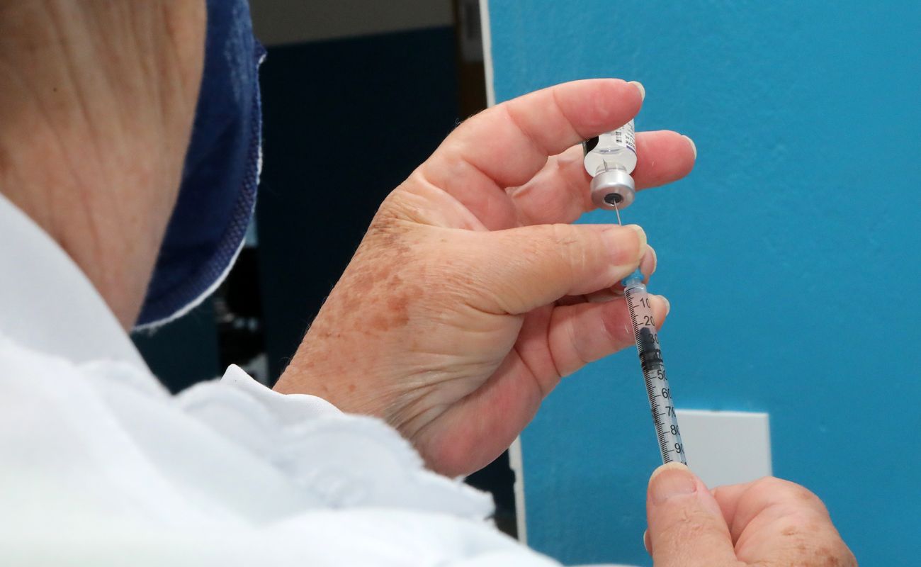 Imagem mostra as mãos de uma enfermeira preparando uma dose da vacina contra a Covid-19, em uma das Unidades Básicas de Saúde.