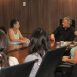 Imagem mostra o prefeito Guilherme Gazzola conversando com a secretária de Promoção Social, junto a 6 mulheres, em uma mesa na sala de reuniões do gabinete. Trata-se da posse de novos membros do Conselho dos Direitos da Mulher