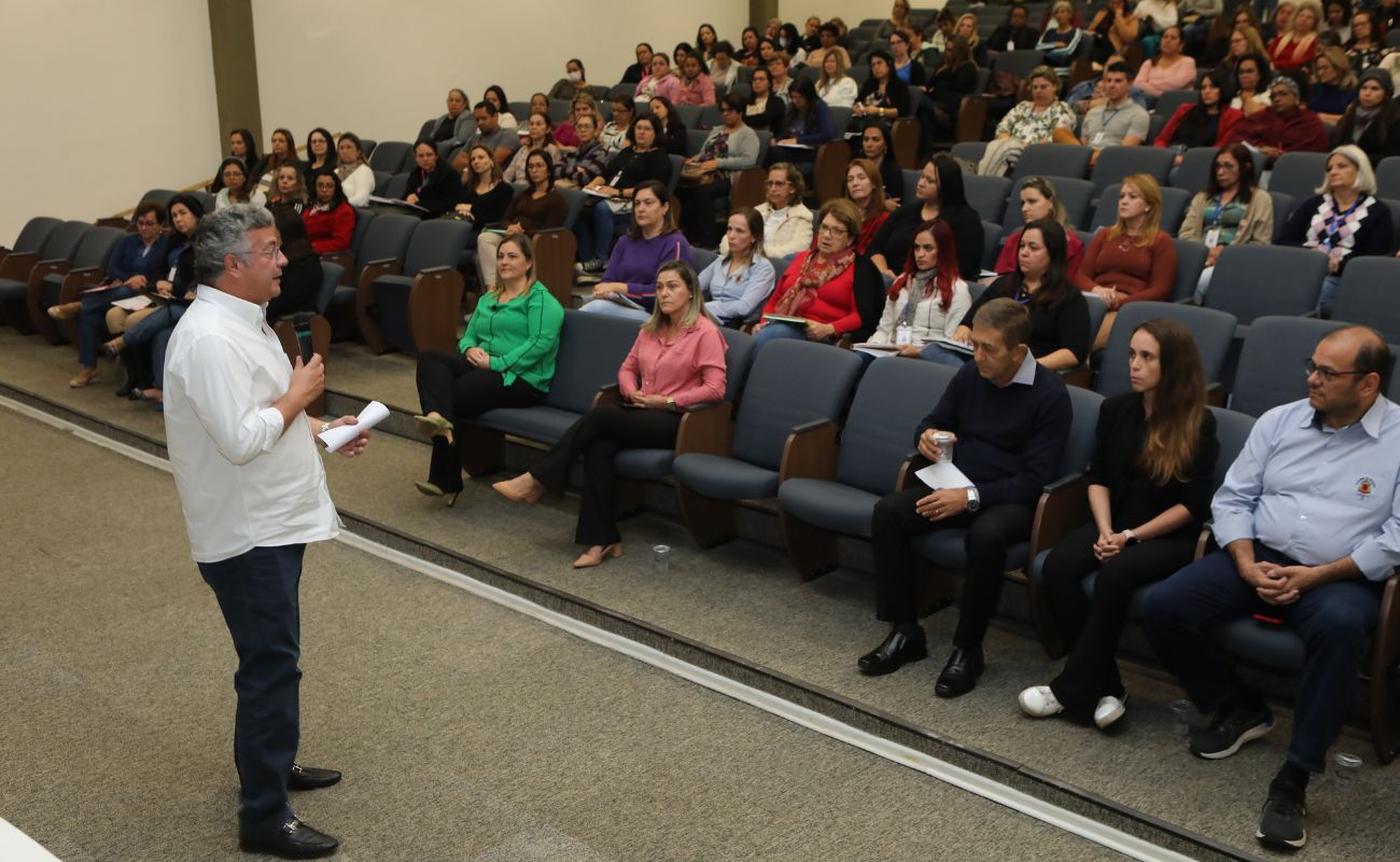 Imagem mostra o prefeito Guilherme Gazzola conversando com os profissionais de educação sobre o uso do botão de emergência.