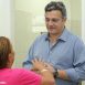 Imagem mostra o prefeito Guilherme Gazzola conversando com uma munícipe, aparentemente senhora de camiseta rosa em uma das Unidades Básicas de Saúde que fazem parte do programa Zera Fila da Saúde