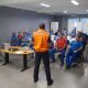 Imagem mostra diretor de Proteção e Defesa Civil, Paulo Guerreiro ministrando uma palestra sobre a prevenção de queimaduras urbanas aos funcionários da empresa Fox Reciclagem