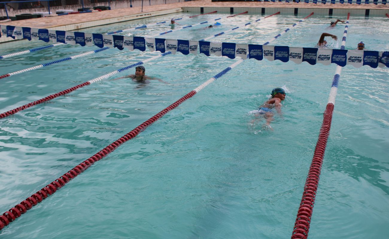 Imagem mostra piscina com duas pessoas participando de uma das aulas de natação em Itu