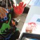Imagem mostra em foco as mãos de uma criança pintada de vermelho em uma das brincadeiras na manhã das crianças, um evento que faz parte da Semana da Primeira Infância realizada no ano anterior.