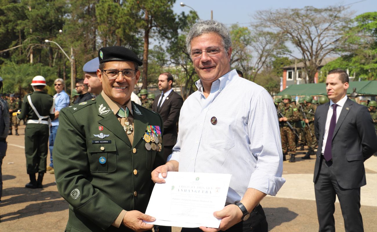 Imagem mostra o prefeito Guilherme Gazzola junto ao general, Agnaldo de Oliveira Santos recebendo em mãos o Título de Amigo da Brigada.