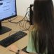 Imagem mostra mulher de costas sentada olhando para uma tela de computador os cursos com oportunidade de contratação do Via Rápida