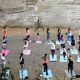 Imagem mostra pessoas em aula de yoga gratuita realizada mensalmente no Parque do Varvito.