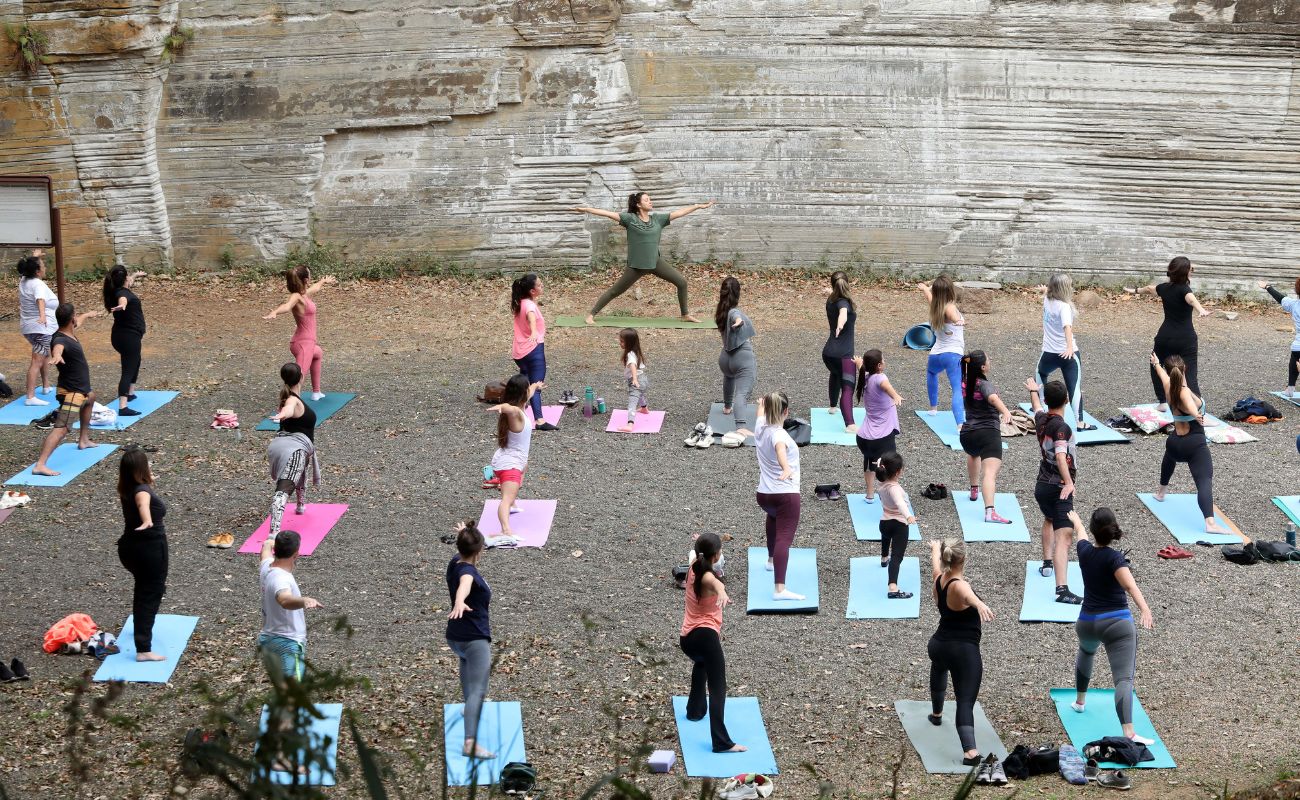 Imagem mostra pessoas em aula de yoga gratuita realizada mensalmente no Parque do Varvito.