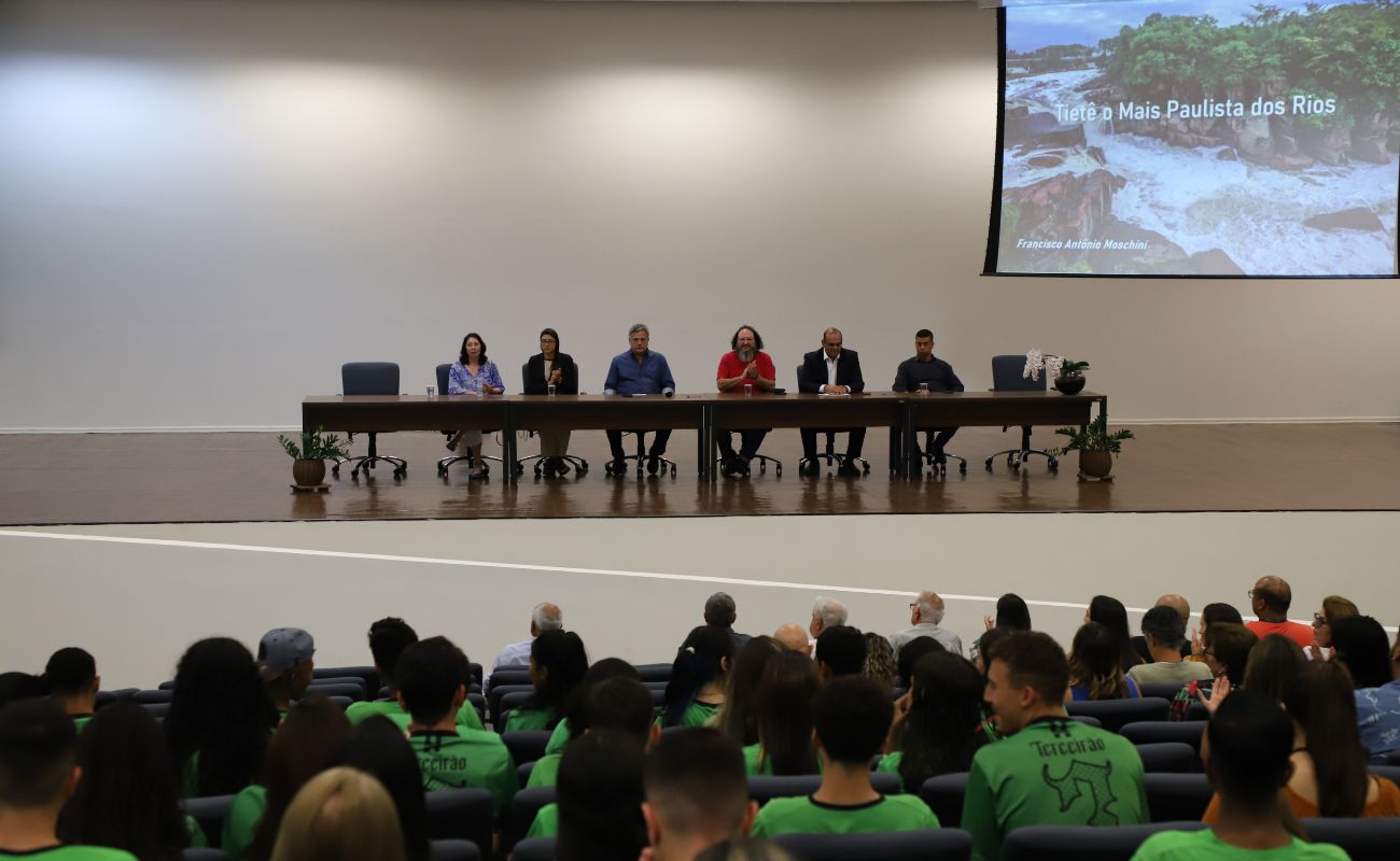 Imagem mostra o prefeito Guilherme Gazzola ao lado de autoridades, todos sentados em uma mesa no palco do auditório da Prefeitura de Itu, no 1º Seminário "Tietê, o mais paulista dos rios"