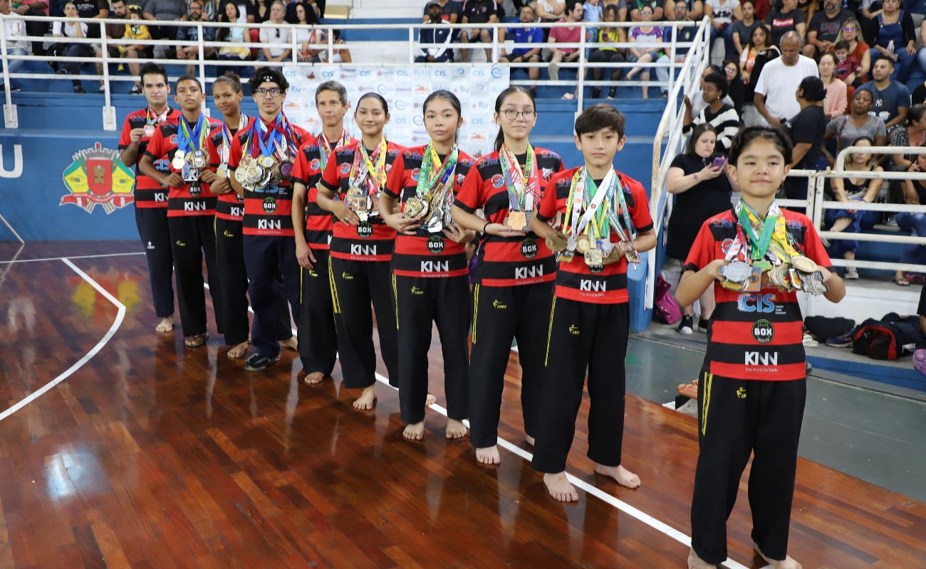 Imagem mostra os competidores que participaram do Festival de Taekwondo exibindo suas medalhas.