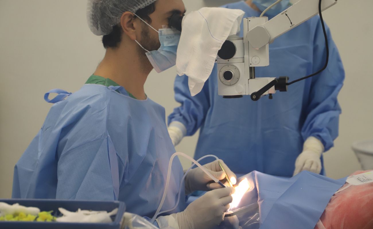 Imagem mostra um médico sentado em momento de realização de uma das suas cirurgias de catarata.