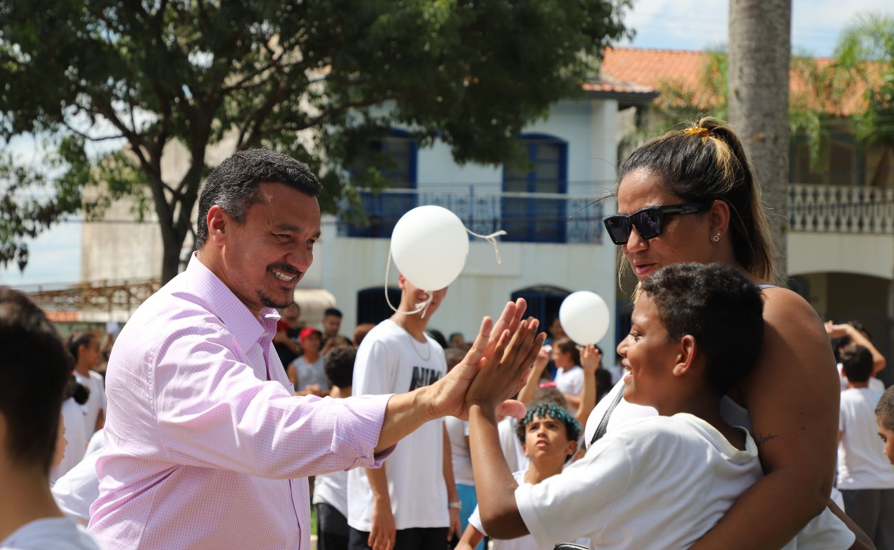 Imagem mostra o Secretário de Planejamento Gilmar Pereira com uma criança, junto a sua mãe de mãos dadas