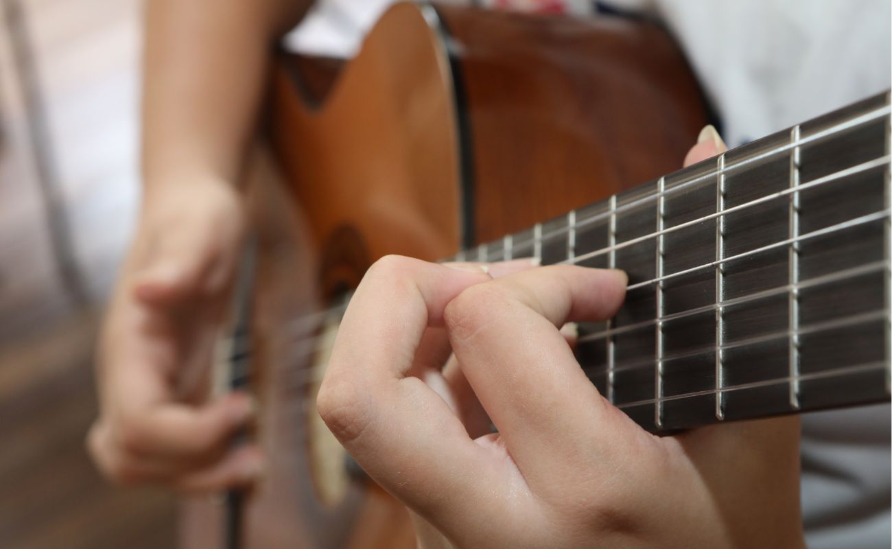 Imagem mostra em foco mãos tocando violão, um dos instrumentos em destaque no Festival de Artes de Itu