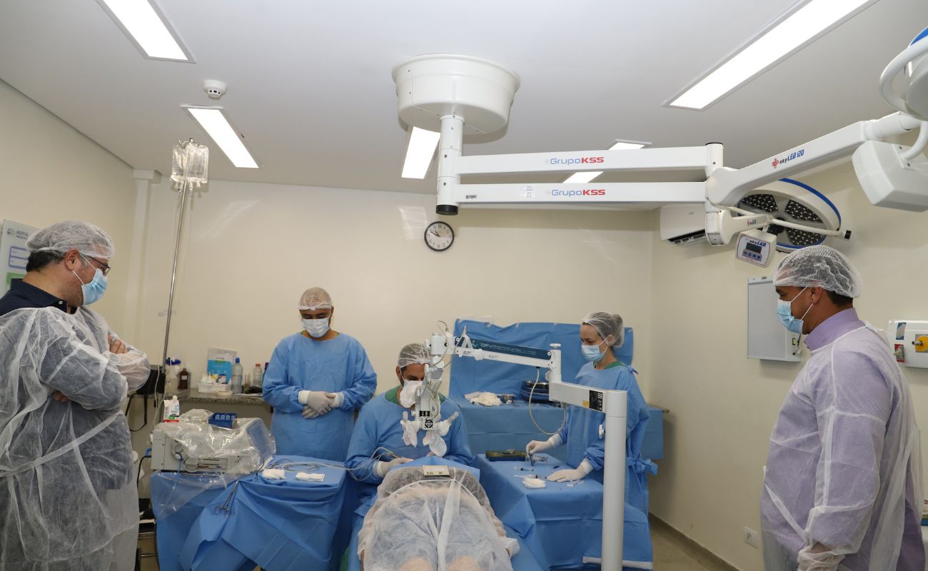 Imagem mostra o prefeito Guilherme Gazzola junto ao Secretário de Planejamento Gilmar Pereira em sala de cirurgia, junto a equipe médica e paciente em momento de procedimento no Mutirão da Catarata.