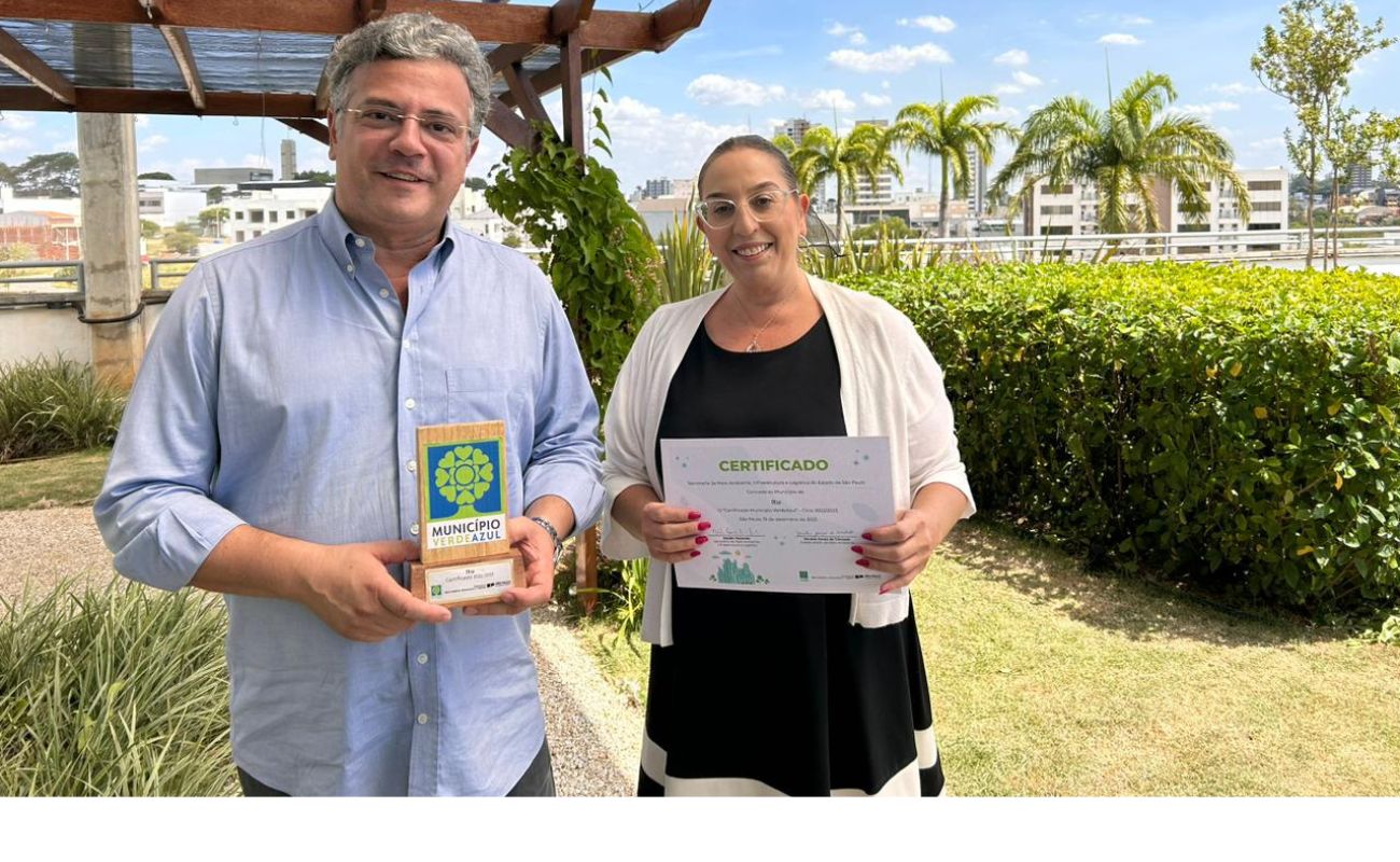 Imagem mostra o prefeito Guilherme Gazzola junto a Secretária de Justiça Maria Teresa, com o prêmio Município Verde Azul em mãos.