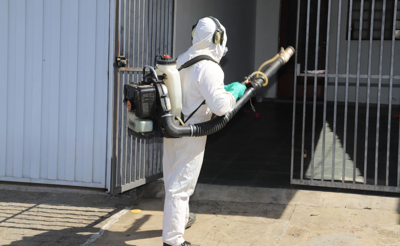 Imagem mostra um agente sanitário em momento de ação realizando fumacê em uma residência em Itu.