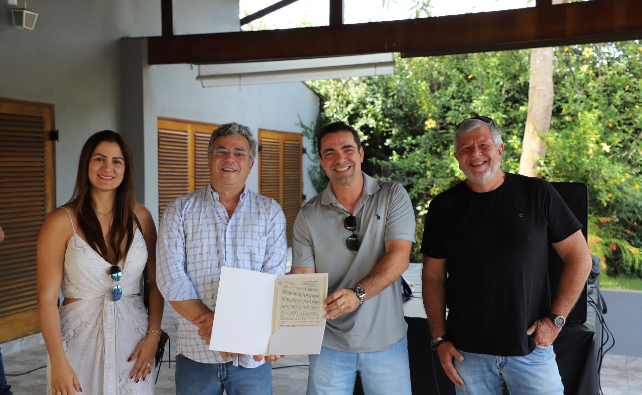 Imagem mostra o prefeito Guilherme Gazzola com o secretário de habitação José Roberto Barreira e moradores do Loteamento Padovan