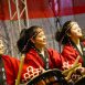 Imagem mostra 3 mulheres vestidas com kimono vermelho em momento de apresentação na edição anterior da Festa Japonesa, organizada pela Acendi.