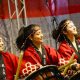 Imagem mostra 3 mulheres vestidas com kimono vermelho em momento de apresentação na edição anterior da Festa Japonesa, organizada pela Acendi.
