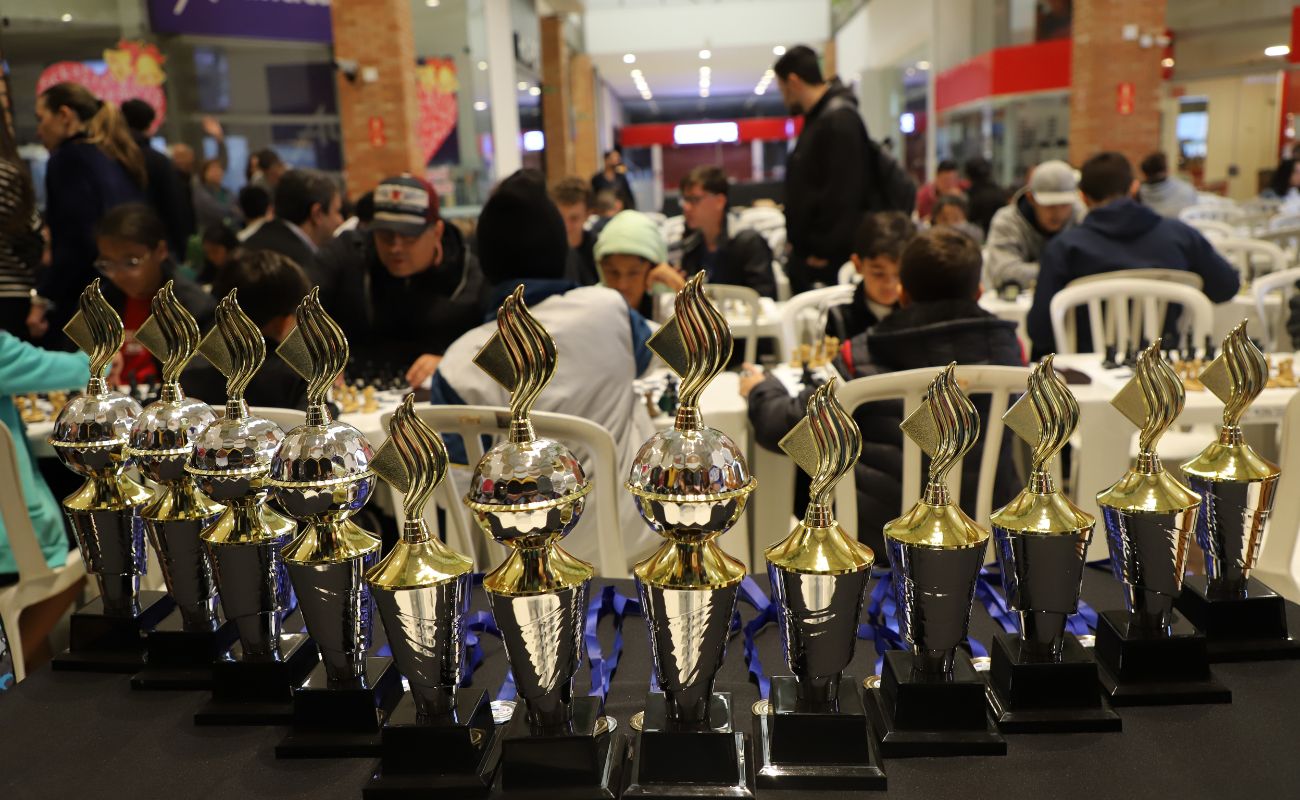 Imagem mostra em foco os troféus que serão dados como premiação no Festival de Xadrez.