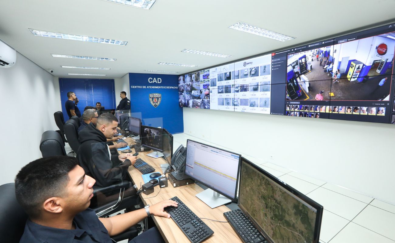 Imagem mostra homens da GCM trabalhando em sala de Monitoramento e Inteligência.