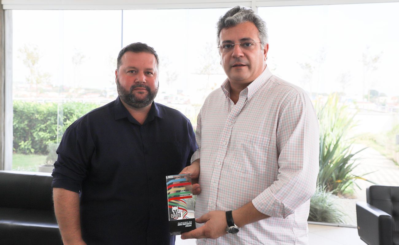 Imagem mostra o prefeito Guilherme Gazzola junto ao Secretário de Esportes Diego Corsi segurando o troféu de “Parceiros do Sesi-Esporte 2024