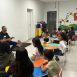 Imagem mostra o arte-educador Thomas Rodrigo de Oliveira junto as crianças conduzindo uma oficina que envolveu a apresentação de temas relacionados ao Comitê das Crianças