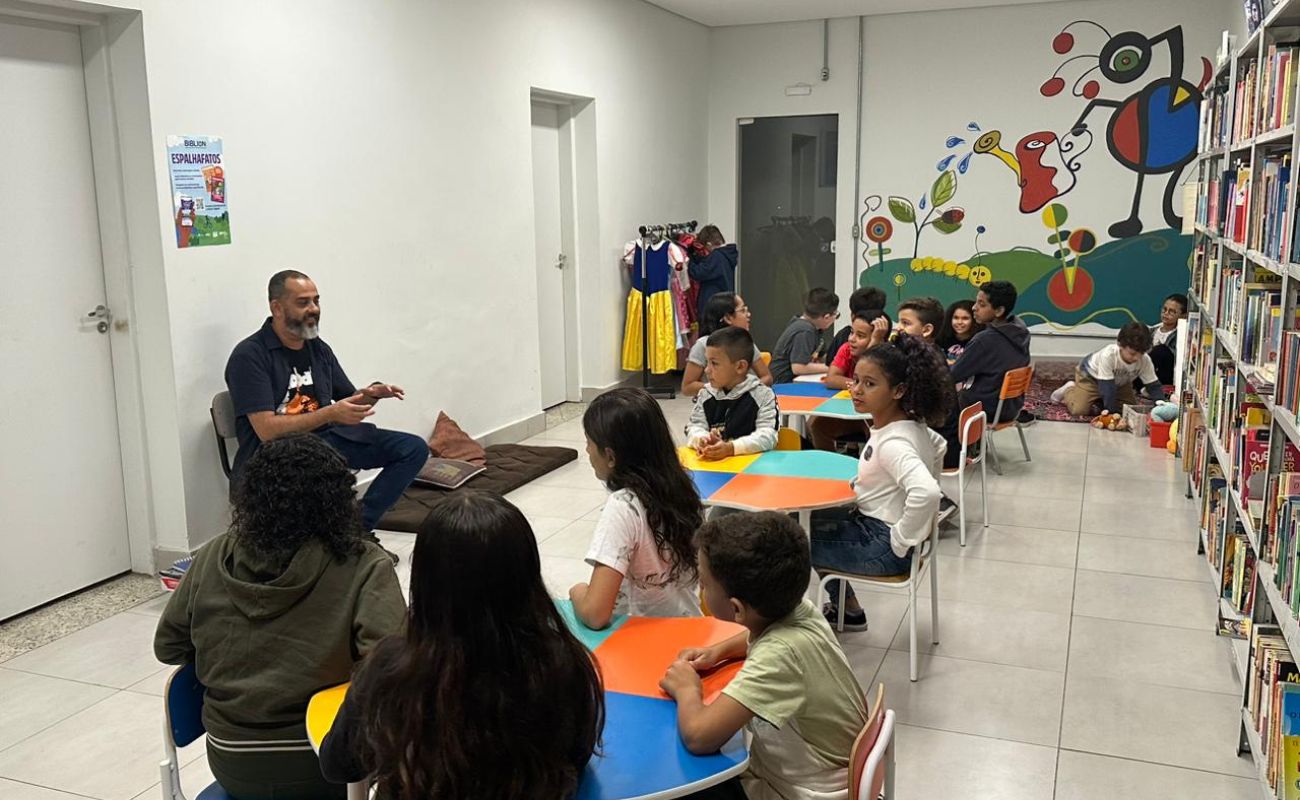 Imagem mostra o arte-educador Thomas Rodrigo de Oliveira junto as crianças conduzindo uma oficina que envolveu a apresentação de temas relacionados ao Comitê das Crianças
